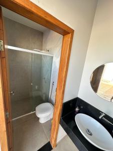 ein Badezimmer mit einem WC, einem Waschbecken und einem Spiegel in der Unterkunft RECANTO DA LU in Maringá