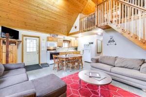 ein Wohnzimmer mit einem Sofa und einem Tisch in der Unterkunft Cozy Birchwood Retreat on UTV Trail with Hot Tub! in Birchwood