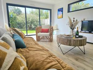 a living room with a couch and a coffee table at Villa avec jardin,proche port du Crouesty 500 m et des plages 2km in Arzon
