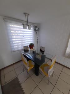 ein Esszimmer mit einem Tisch, Stühlen und einem Fenster in der Unterkunft Nova Vida in Santiago