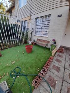 une cour avec un tuyau de jardin et un banc dans l'établissement Nova Vida, à Santiago