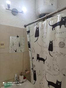 a bathroom with a shower curtain with cats on it at Habitación privada en apto cat friendly in Montevideo