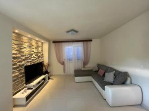 a living room with a couch and a television at Holiday house Karla in Vela Luka