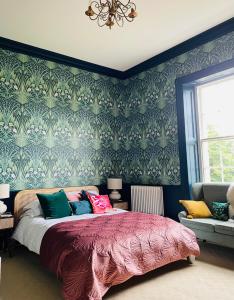 a bedroom with a bed with a floral wallpaper at Norfolk House Hosted by The Scarlet Hen in Huddersfield