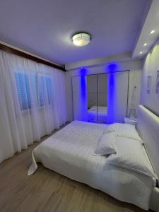a bedroom with a large bed with blue lighting at Holiday house Karla in Vela Luka