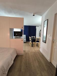 a bedroom with a bed and a kitchen and a table at studio tout équipé in Jausiers +24 photos