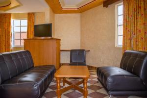a waiting room with leather furniture and a flat screen tv at Auto Hotel Estrella del Sur in Oaxaca City