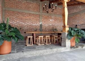 a wooden table and stools under a brick wall at Casa Brisa in Tapalpa