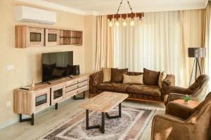 a living room with a couch and a tv at Nora Marmara Luxury Villas in Istanbul in Istanbul