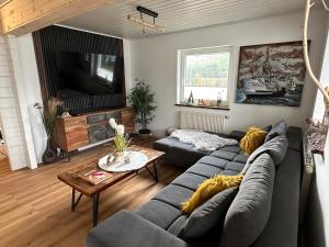 ein Wohnzimmer mit einem Sofa und einem Tisch in der Unterkunft Ferienhaus Wiesenstrasse in Neuhaus an der Oste