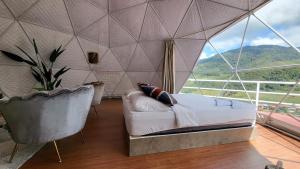 a bedroom with a bed and a large window at Syameen's Glamping Dome in Kundasang