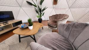 sala de estar con 2 sillas, mesa y TV en Syameen's Glamping Dome en Kundasang