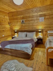 a bedroom with a bed in a wooden room at Guesthouse Marashi in Theth