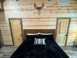 sypialnia z łóżkiem w pokoju z drewnianymi ścianami w obiekcie The Moonlight Dream Cabin! w mieście Broken Bow