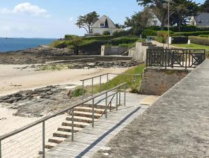 a set of stairs leading to a beach with a house at Villa avec jardin,proche port du Crouesty 500 m et des plages 2km in Arzon