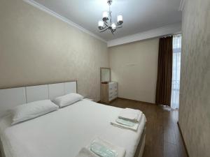 a bedroom with a white bed and a chandelier at Amiryan 4, No 28 in Yerevan