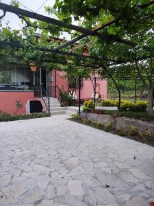 a stone patio in front of a pink building at HAS Bağ Evi 