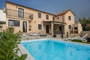 a villa with a swimming pool and a house at Villa Fran, Krk in Sveti Vid-Miholjice