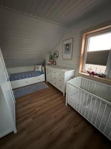 ein Schlafzimmer mit zwei Kinderbetten und einem Fenster in der Unterkunft Ferienhaus Wiesenstrasse in Neuhaus an der Oste