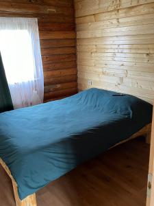 ザラウにあるCabana MOIGRAD-POROLISSUMの窓付きの木造の部屋のベッド1台