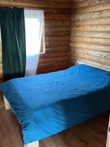 uma cama num chalé de madeira com uma janela em Cabana MOIGRAD-POROLISSUM em Zalău