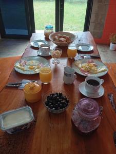 einen Holztisch mit Frühstückszutaten und Orangensaft in der Unterkunft La Casa de Marlon y Karina in Tarapoto