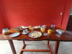 einen Holztisch mit Frühstückszutaten und Getränken darauf in der Unterkunft La Casa de Marlon y Karina in Tarapoto