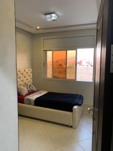 een slaapkamer met een bed en een raam bij Apartamentos Palace Rif Al Hoceima 