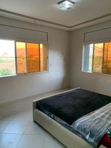 un letto in una camera con due finestre di Apartamentos Palace Rif Al Hoceima 