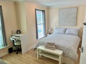 a bedroom with a bed and a desk and a desk at Coco’s Homestay - Sidmouth in Reading