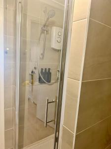 a shower with a shower head in a bathroom at Coco’s Homestay - Sidmouth in Reading