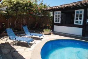 2 sillas y una piscina en un patio en Most Gorgeous Home in Buzios VILLA ATLANTIS, en Armacao dos Buzios