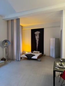 a living room with a bed and a refrigerator at Design Loft in ehemaliger Spinnerei in Mels +35 photos