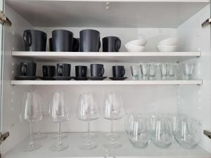 a row of wine glasses and bowls on shelves at Apartma Katarina's place in Bovec