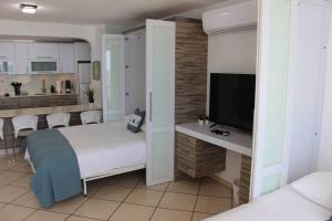 Schlafzimmer mit einem Bett und einem Flachbild-TV in der Unterkunft Sea for Yourself in Fajardo