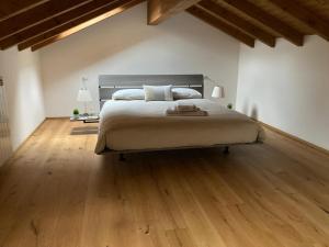 a bedroom with a large bed and wooden floors at Casa Teresa (piano 1) in Germignaga