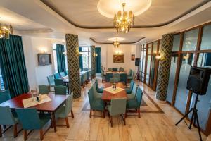 a restaurant with tables and chairs and a television at Garden Resort by Cota 1200 in Predeal