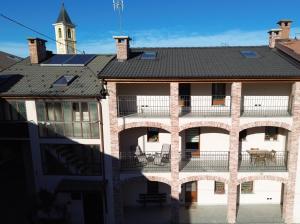 ein Backsteingebäude mit einem Balkon und einem Uhrturm in der Unterkunft Il cortile in Boves