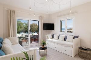 a living room with a white couch and a tv at Corfu Town Luxury Studio -C in Corfu Town