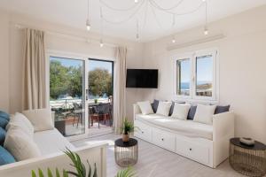 a living room with a white couch and a tv at Corfu Town Luxury Studio -C in Corfu