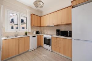 a kitchen with wooden cabinets and a white appliance at Corfu Town Luxury Studio -C in Corfu Town