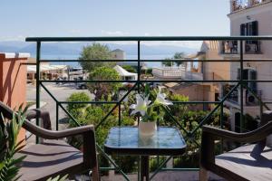 een tafel met een vaas met bloemen op een balkon bij Corfu Town Luxury Studio -C in Corfu-stad