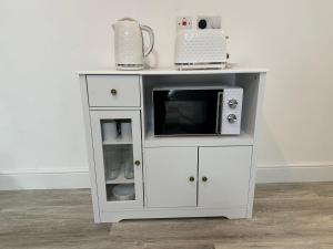 a white cabinet with a microwave on top of it at Luxury en-suite rooms in Southampton