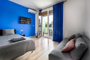 a blue bedroom with a bed and a couch at Park Residence Blue suite- Free parking in Budapest