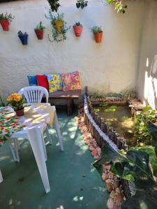 un patio con un banco, una mesa y plantas en Pousada Residencial Porto de Galinhas, en Porto de Galinhas