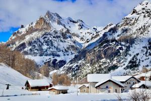 a snow covered mountain with a house in the foreground at ArgenteraBersezio Guest House in Bersezio