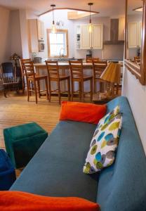 sala de estar con sofá azul y cocina en La Vérivraie/Truly -Hébergement touristique/Tourist accomodation en North Hatley