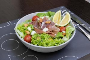 a bowl of salad with meat and vegetables and lemon slices at Holiday Inn Express Santiago Las Condes by IHG in Santiago