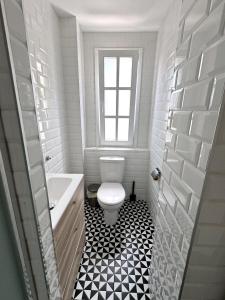 een witte badkamer met een toilet en een raam bij Luxurious Penthouse Studio with Private Terrace - Grand Central House in Gibraltar