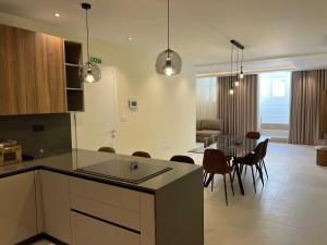 a kitchen and living room with a table and chairs at Superb 3 Bedroom Apartment in Gzira Promenade in Il-Gżira